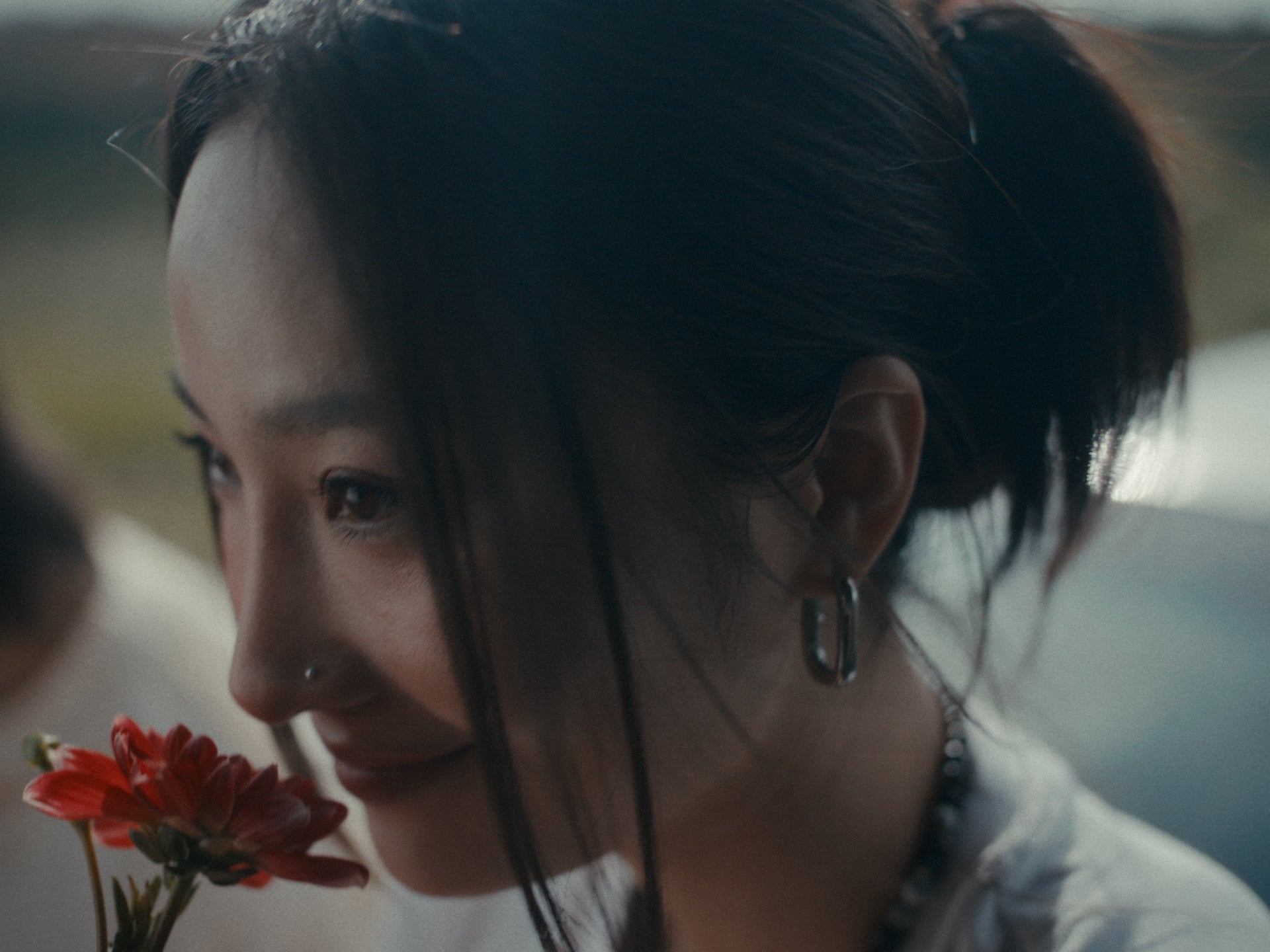Close-up portrait of a woman holding a red flower