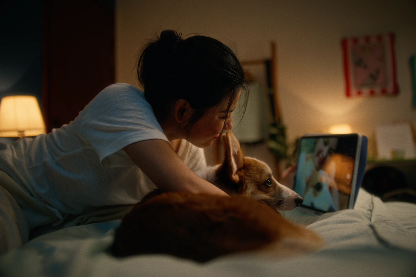 Woman holding a dog in a bedroom